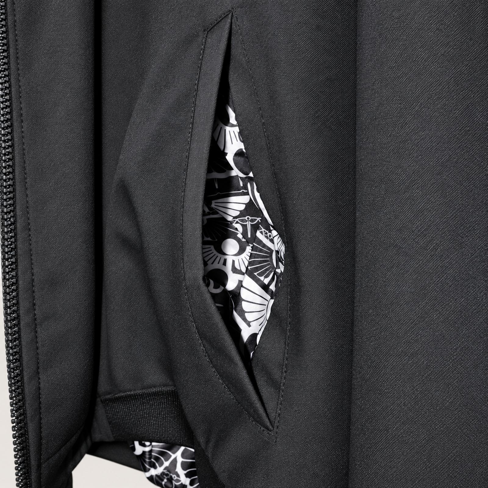 Close-up of the Arterial bomber jacket side pocket, revealing black-and-white printed lining.