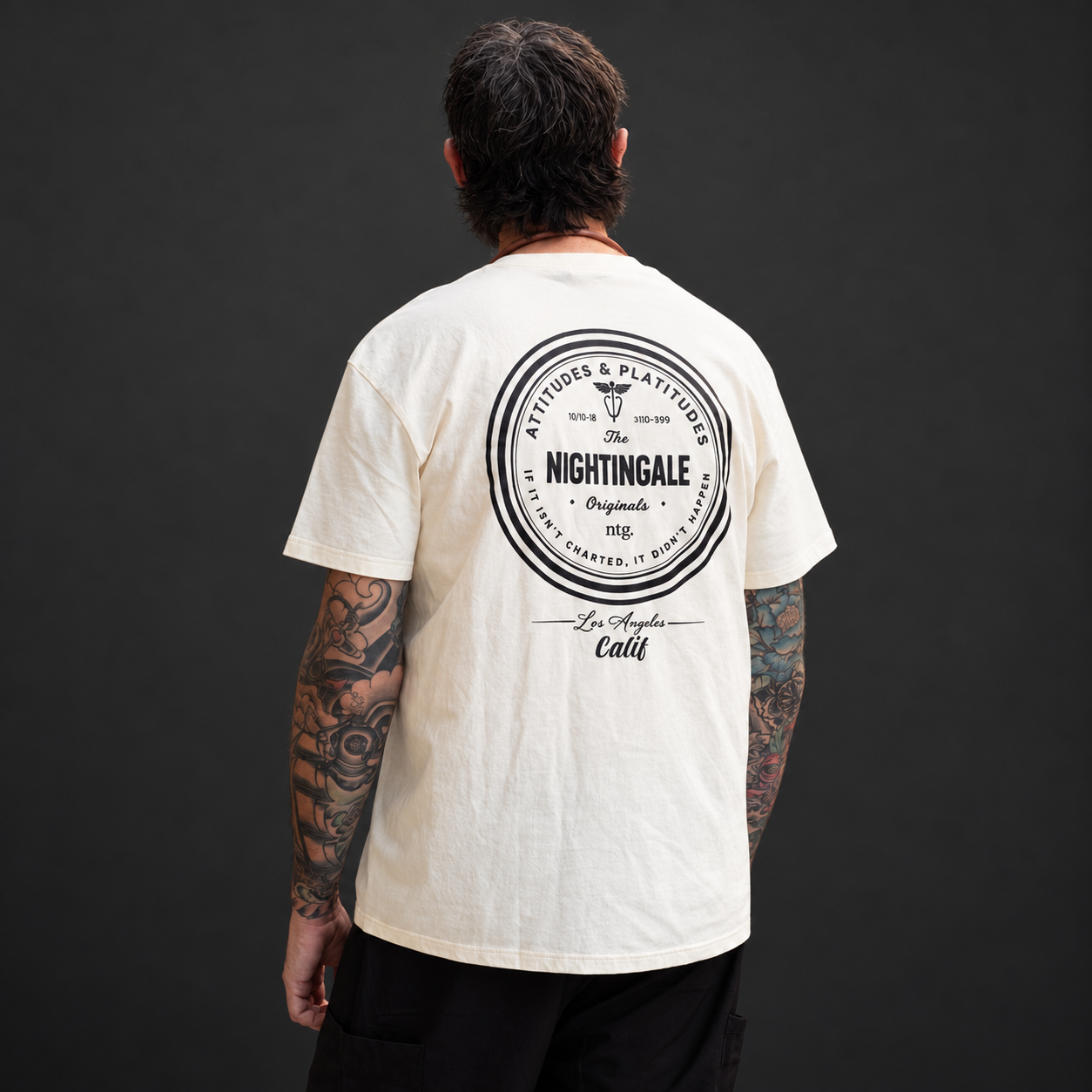 Back view of a cream Sure’t T-shirt showing a large circular Nightingale Originals graphic.