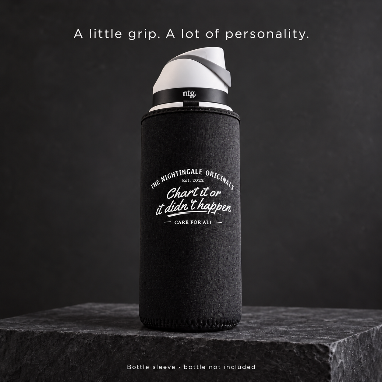 Black Clutch’d sleeve fitted around an NTG tumbler with a white-and-gray lid on a dark stone plinth.