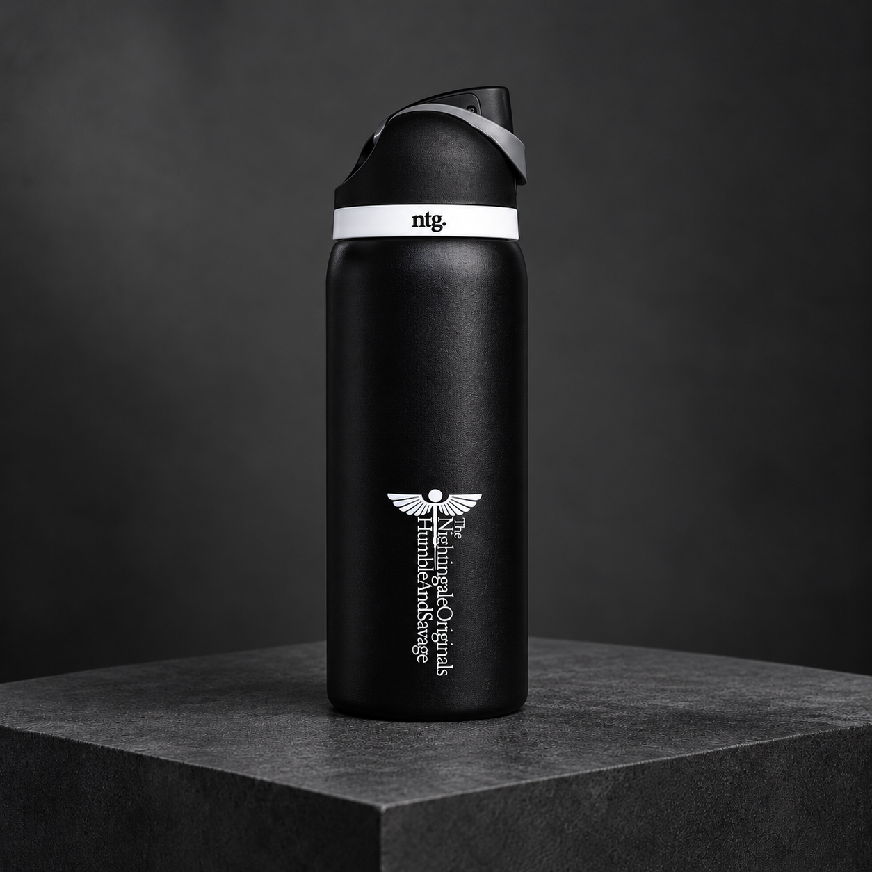 Black Parch’d flip-top tumbler with a white medical emblem displayed on a charcoal stone plinth.