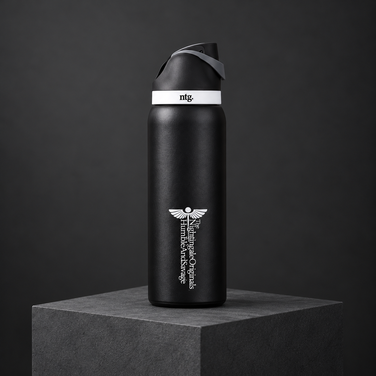 Three-quarter studio view of a black Parch’d tumbler and flip-top lid on a charcoal plinth.
