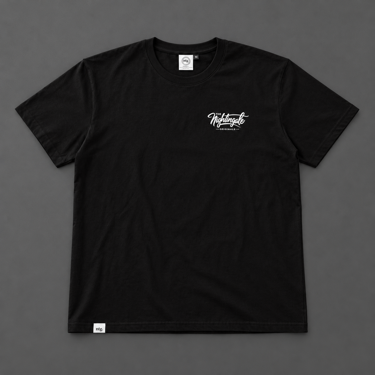 Front of a black Sure’t T-shirt with a small white Nightingale Originals script print.